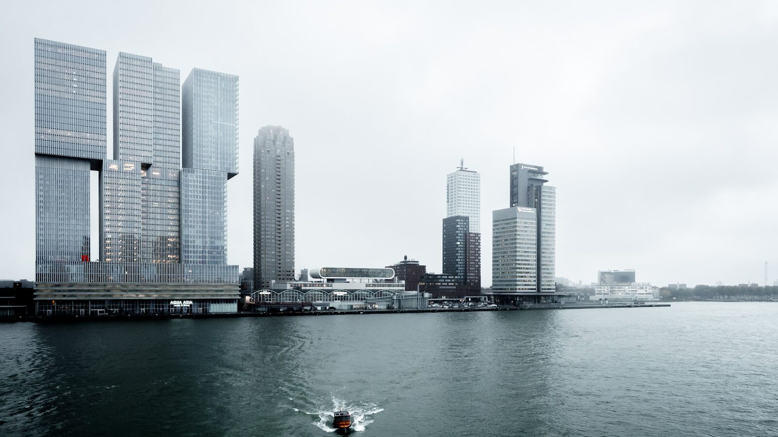 boat in the water with high-rise building in the background