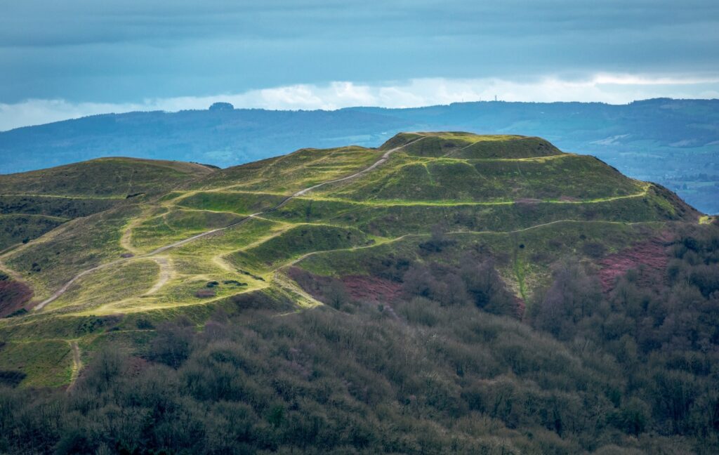 a grassy hill with a winding road on top of it