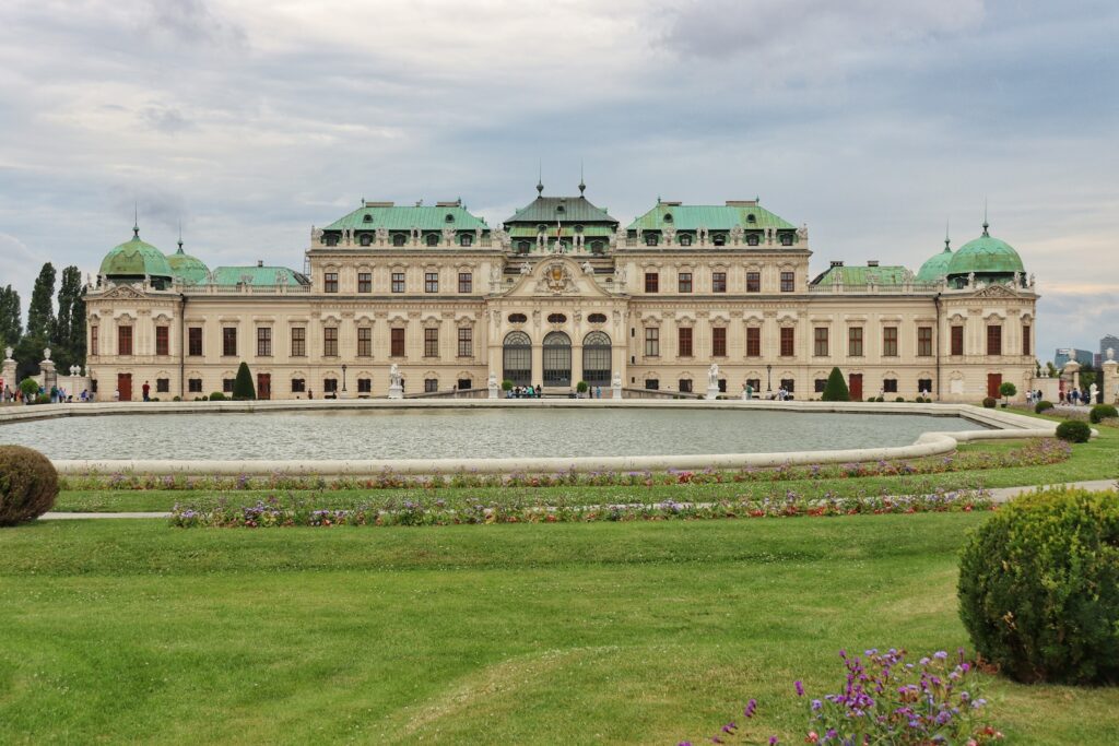 a large building with a fountain in front of it with Belvedere, Vienna in the background